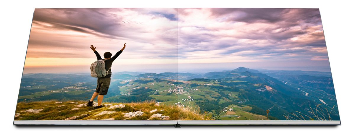 Fotobuch mit Layflatbindung und Bergsteiger vor Landschaft.